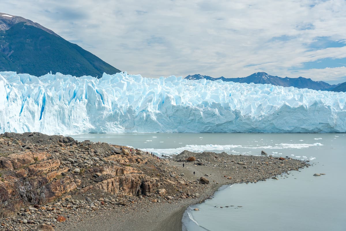 Perito Moreno Glacier calving into Lago Argentino — the 5km-wide, 70m-high ice face advancing in front of Patagonia's mountains. UNESCO 1981.